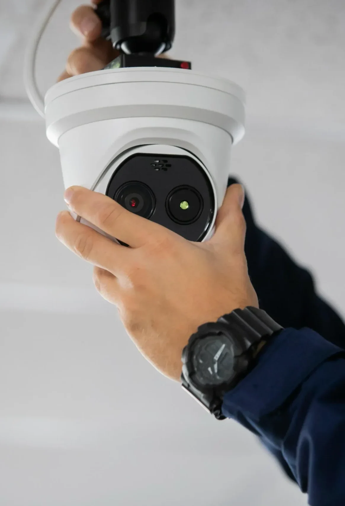 Security camera installer mounting a dome CCTV camera on an indoor ceiling